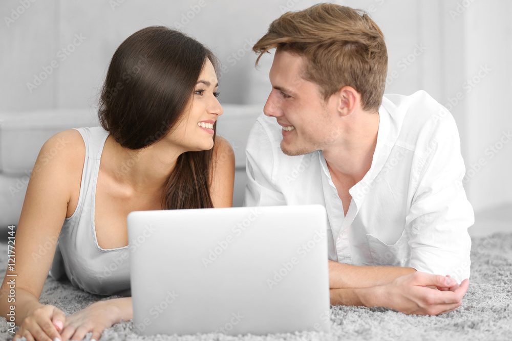 Beautiful couple surfing internet on laptop at home Beautiful couple surfing internet on laptop at home