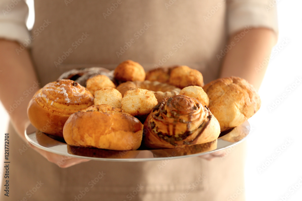 Woman holding fresh bakery products, closeup