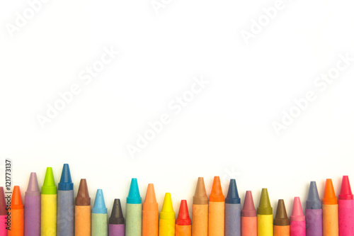 Colorful crayons in an irregular row on white background