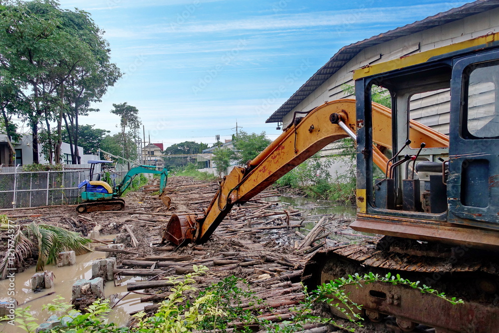 Heavy back hoe truck and small back hoe truck for constructing the walkway on canal. Heavy back hoe truck and small back hoe truck for constructing the walkway on canal.