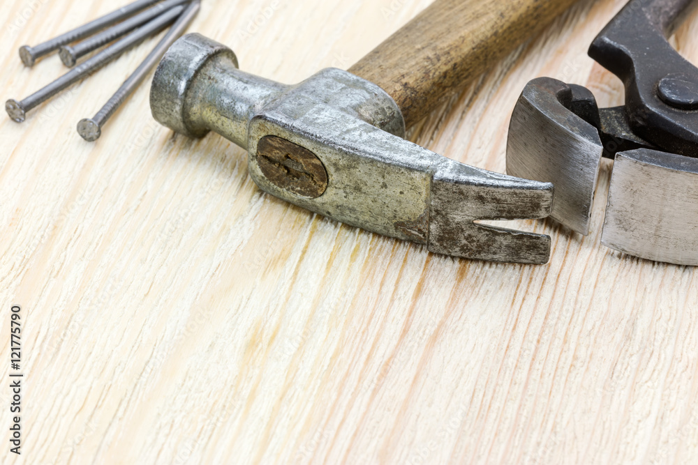 hammer, nails and pincers on wooden board background hammer, nails and pincers on wooden board background