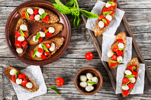 bruschetta with caprese salad on rye baguette with seeds