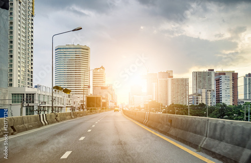 Photography Urban road with skyscraper at sunset shining