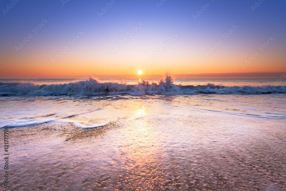 Wave on the beach at sunset.