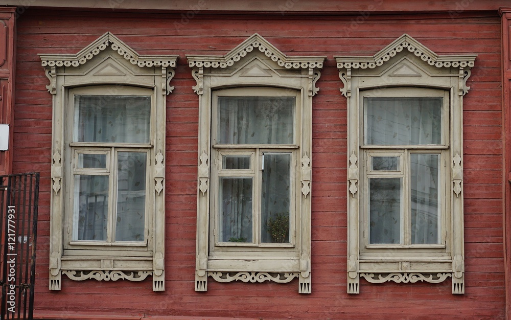 Окна с разными деревянными наличниками в деревянном доме Центральной России 