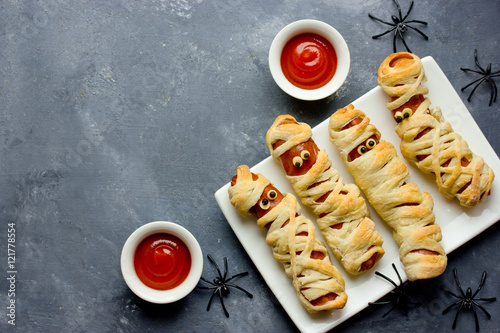 Halloween background. Funny sausage mummies with ketchup for halloween