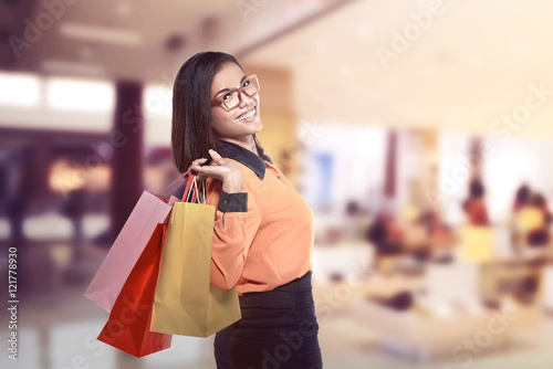 Happy asian woman holding shopping bags and smiling