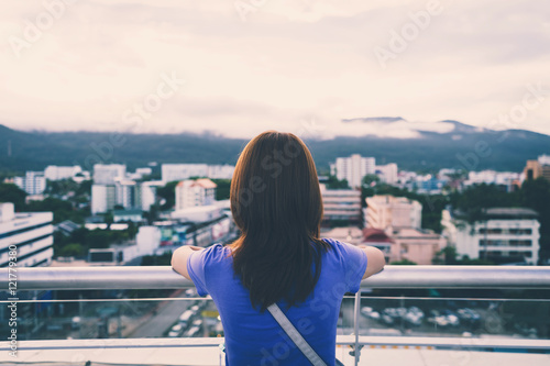 Hipster young girl looking the city on observation deck