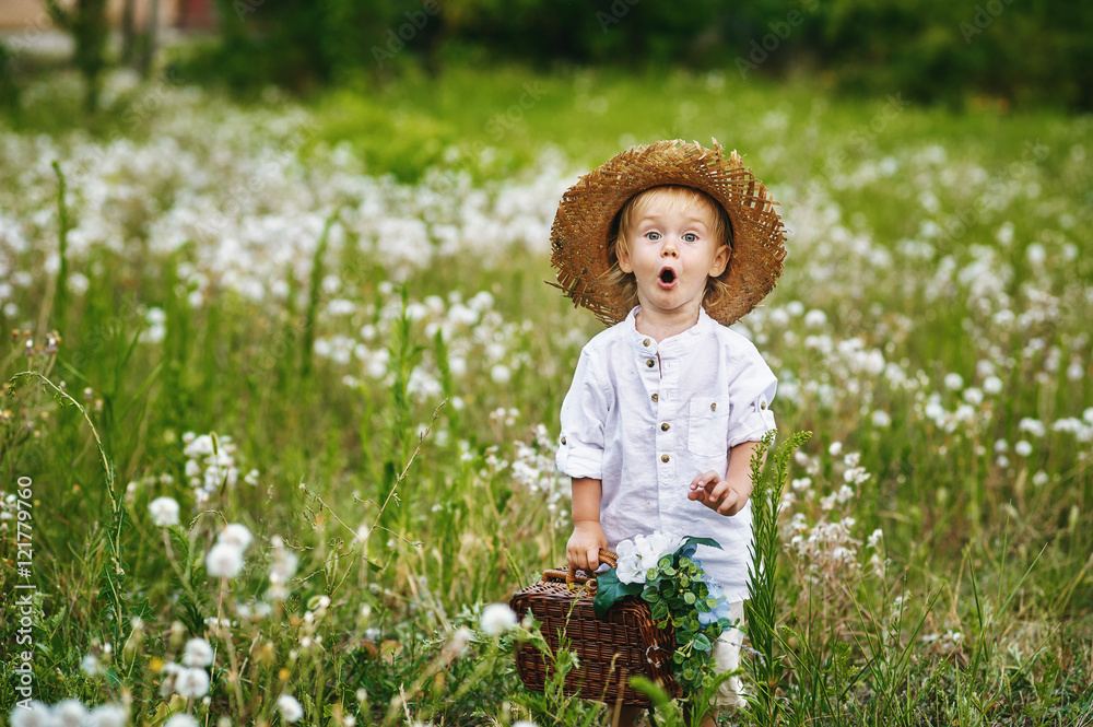 Little boy in field with dandelions , dressed in retro clothes