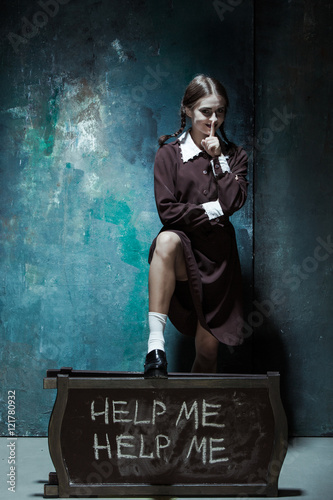 Portrait of a young smiling girl in school uniform as killer woman photo
