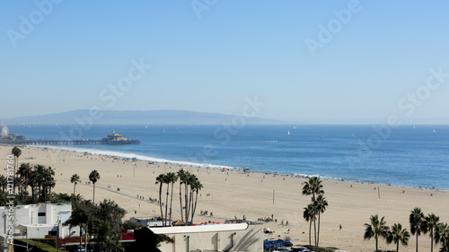 The beach is in the Santa Monica  California. The Pacific Ocean is in the Los Angeles on a Sunny day.