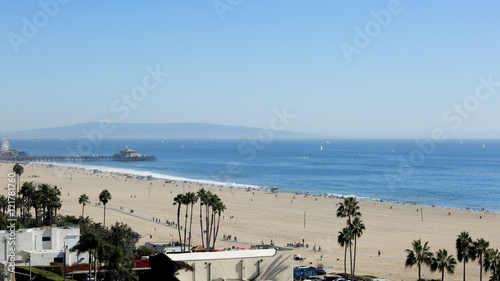 The beach is in the Santa Monica, California. The Pacific Ocean is in the Los Angeles on a Sunny day.