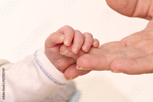 hand of a baby holding the hand of his mother