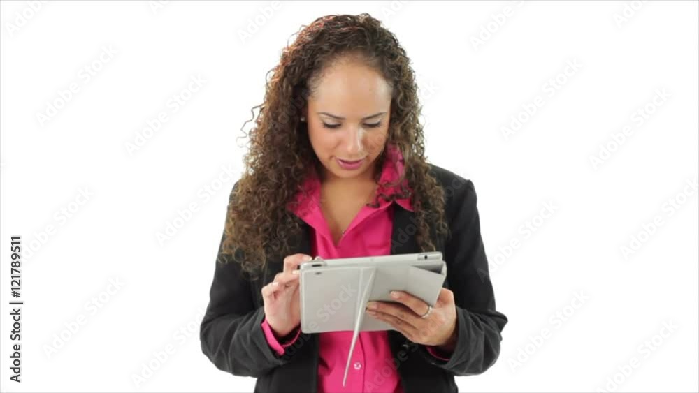 An amused Hispanic woman entertained by what she sees on an electronic tablet stops and smiles at the camera. An amused Hispanic woman entertained by what she sees on an electronic tablet stops and smiles at the camera.