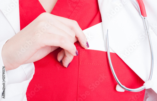 Successful female doctor putting visit card in pocket