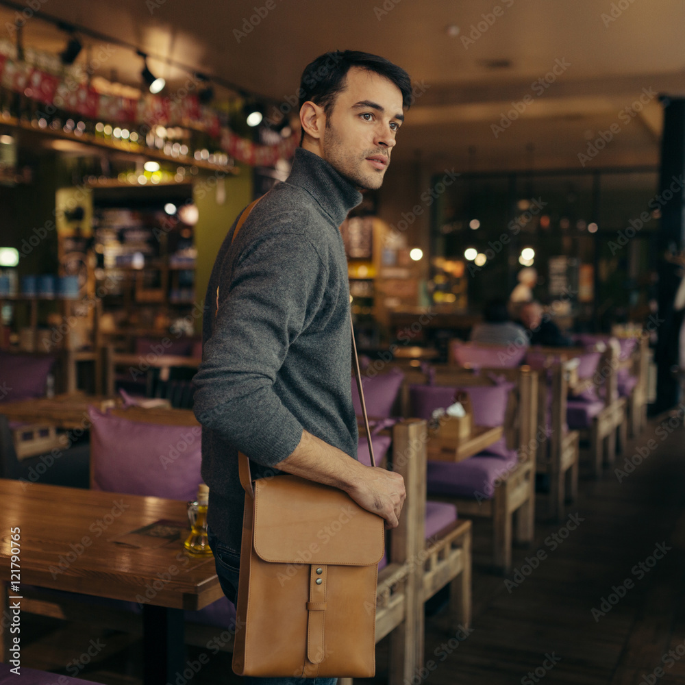 Handsome businessman with leather bag on his shoulder