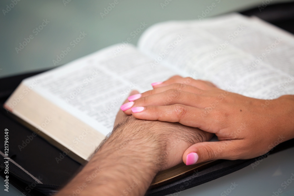 Obraz premium Couple with hands on Bible