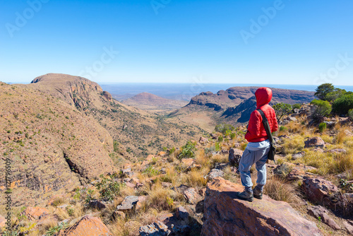 Tourist standing on rock and looking at the panoramic view in Marakele National Park, one of the travel destination in South Africa. Concept of adventure and traveling people. © fabio lamanna