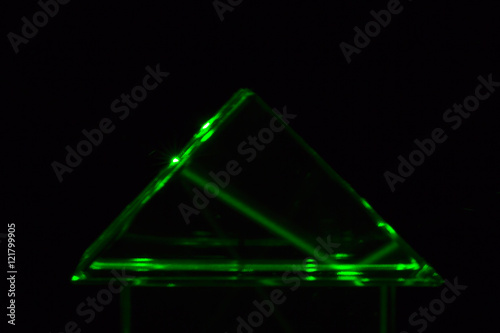 Grüner Laserstrahl, der durch ein Prisma fällt