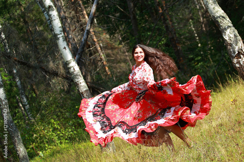Gypsy girl in national dress dancing in the forest