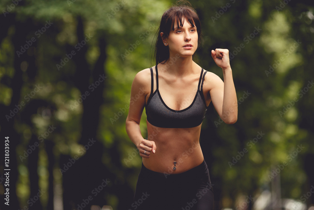 Gorgeous fitness girl with muscular figure runnig on summer day Gorgeous fitness girl with muscular figure runnig on summer day