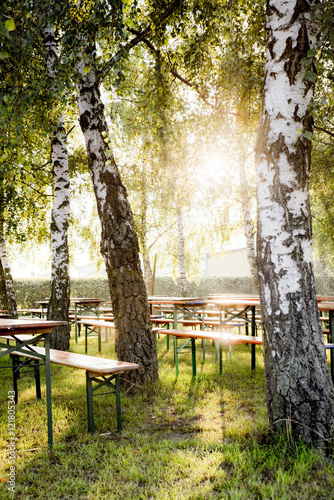 Biergarten im Sonnenschein unter Bäumen 