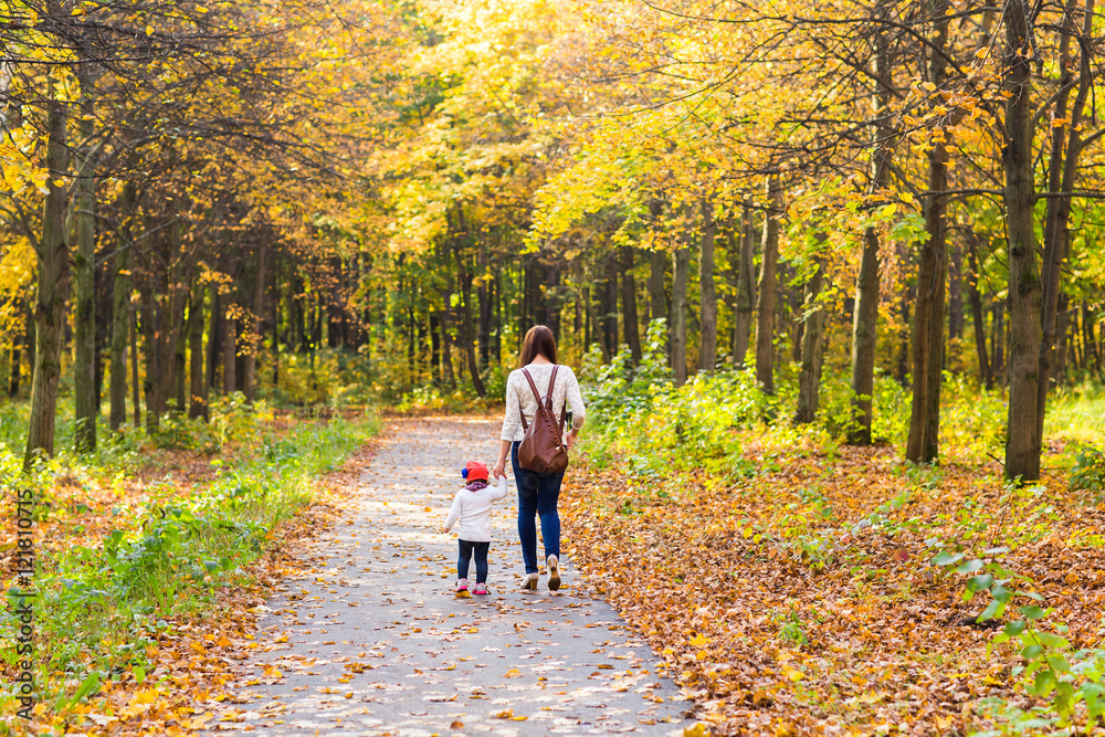 Fototapeta premium Young mother with her little baby girl in the autumn park