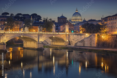 Fototapeta Rome. View of Vittorio Emanuele Bridge and the St. Peter's cathedral in Rome, Italy at night.