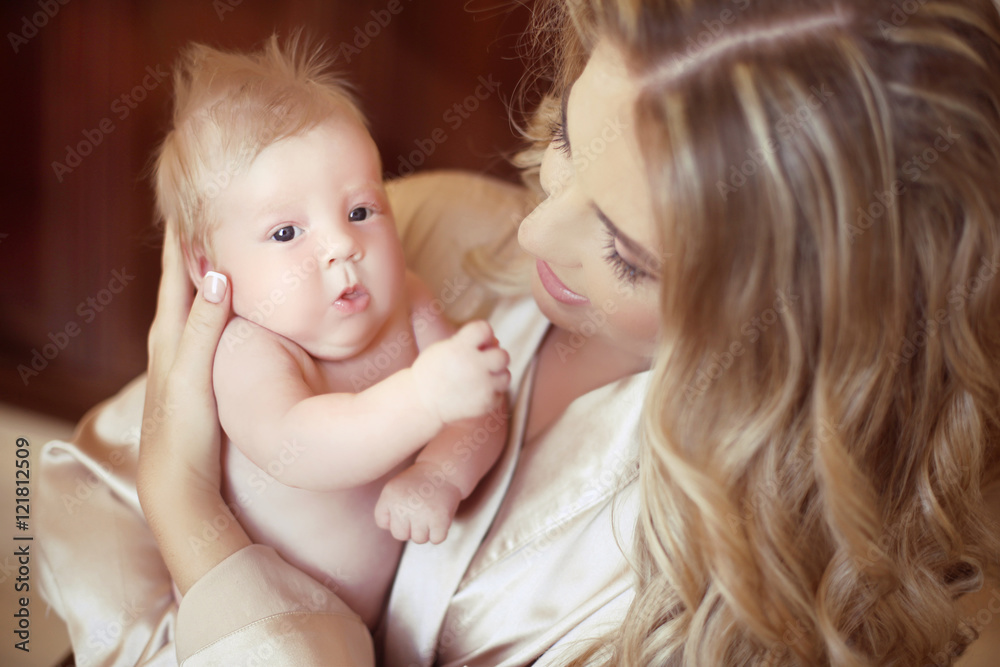 Young mother holding her newborn baby. Mom playing with new born Young mother holding her newborn baby. Mom playing with new born