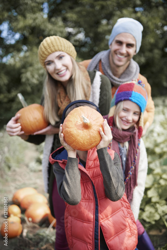 Family with pumpkins in autumn day