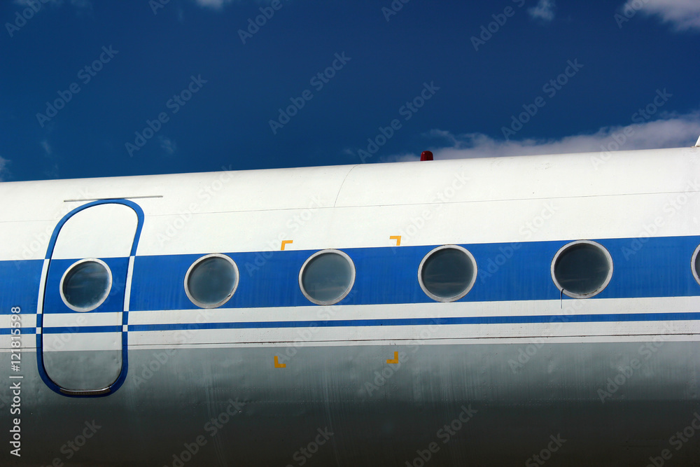 Old passenger aircraft door and windows against blue sky background Old passenger aircraft door and windows against blue sky background