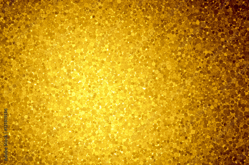 Yellow background with light spot of expanded polystyrene. Pattern from  slice of polystyrene on a gleam. Transparent, show through material