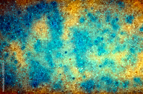 Multicolor self-illumination background of expanded polystyrene. Colored patches pattern. Pattern from slice of polystyrene on a gleam