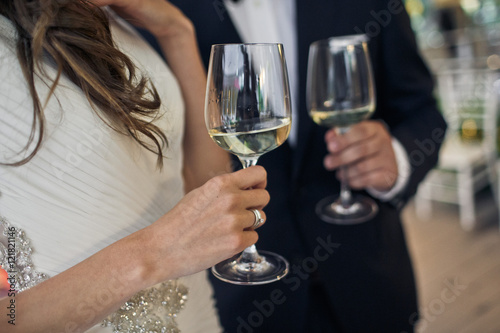 Goblets of the champagne in the hands of the newlyweds