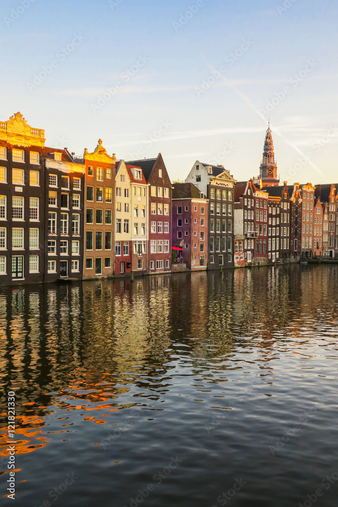 Bunte, sich im Wasser spiegelnde Häuserzeile in Amsterdam, Abendsonne