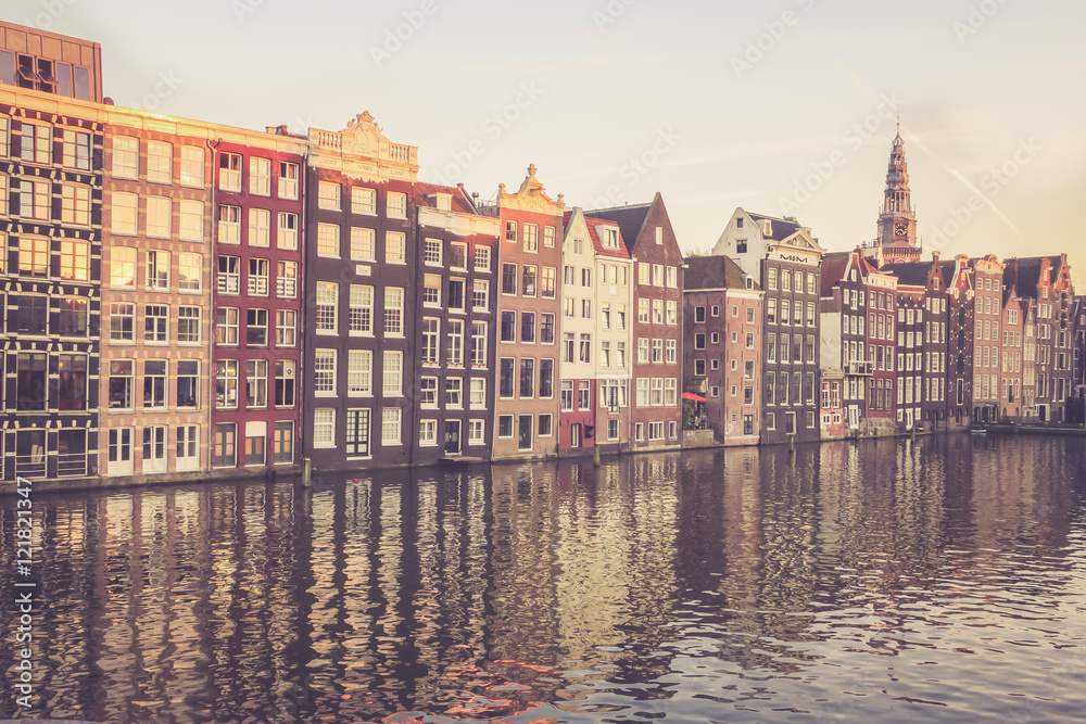 Bunte, sich im Wasser spiegelnde Häuserzeile in Amsterdam, Abendsonne