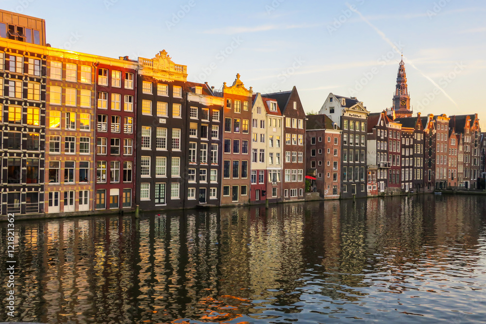 Naklejka premium Bunte, sich im Wasser spiegelnde Häuserzeile in Amsterdam, Abendsonne