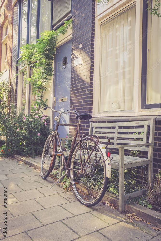 Geparktes Fahrrad in Amsterdam, Parkbank und Häuserzeile, retro 