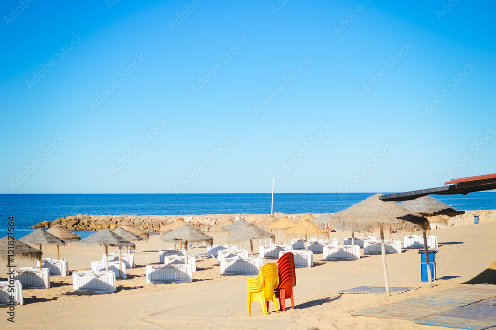 Blue sky and straw umbrella on a beautiful tropical beach background