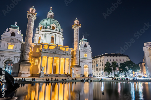 Karlskirche or St. Charles's Church - one of famous churches in Vienna, Austria. Beautiful night photography with illumination and reflection in the water. Travel photo of Vienna.