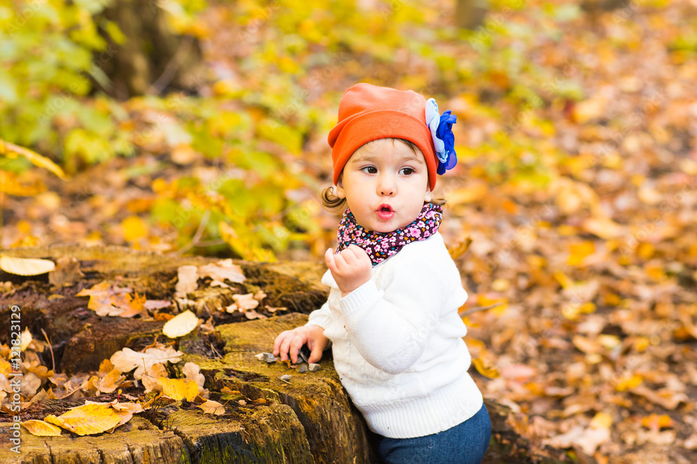 Cute girl sitting and stump in the autumn forest. Cute girl sitting and stump in the autumn forest.