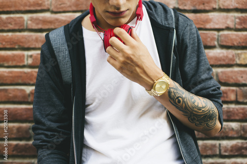 Teenager with a golden clock and tattoo on forearm photo