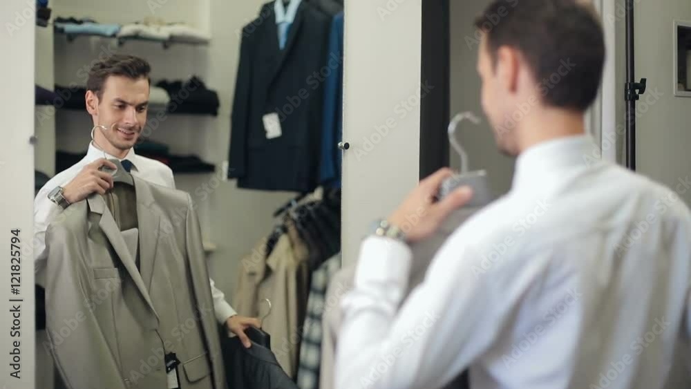 Man choosing a suit at clothing store Man choosing a suit at clothing store