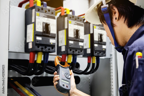 Technician is measuring voltage or current by Clampmeter