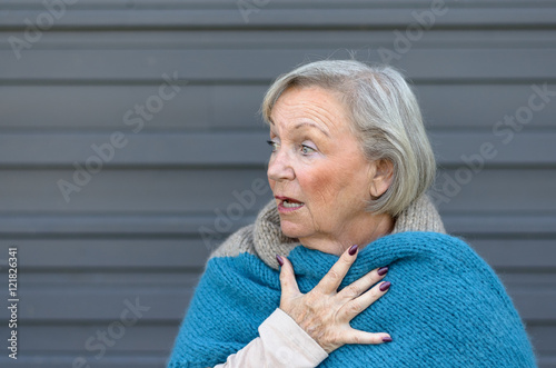 Foto Startled elderly woman clasping her chest