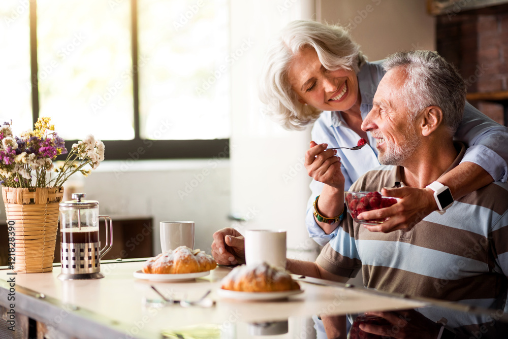 Retired man and woman having breakfast in the kitchen
