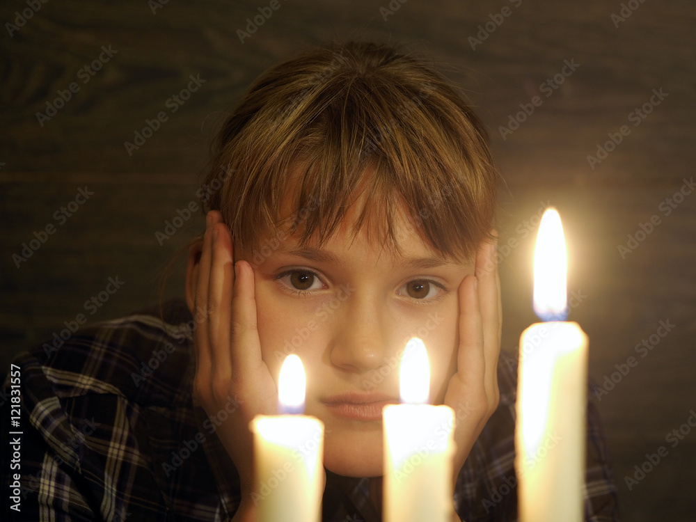 The face of a beautiful girl, and three burning candles. Portrait The face of a beautiful girl, and three burning candles. Portrait