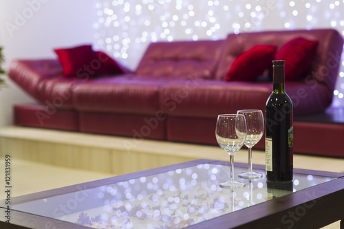 Interior with a coffee table, a sofa and a bottle of wine