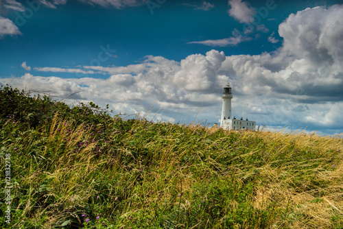 Flamborough lighthouse set in a landscape against a lovely clouded sky.