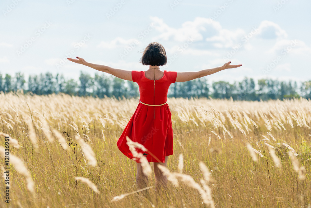 girl in red dress walking on the field girl in red dress walking on the field